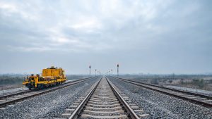 Vías de alta velocidad ferroviaria con señalización técnica bajo cielo nublado.