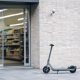 Patinete eléctrico situado en un espacio comercial junto a una cámara de seguridad.